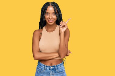 Güzel İspanyol kadın, günlük kıyafetler giymiş, yüzünde kocaman bir gülümseme var. Eli ve parmağı kameraya bakıyor.. 