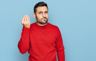 Gündelik kıyafetler giyen genç İspanyol adam İtalyan jesti yapıyor. El ve parmaklarıyla kendinden emin ifade ediyor. 