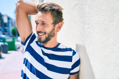 Sakallı yakışıklı beyaz adam, dışarıda mutlu bir şekilde gülümsüyor.