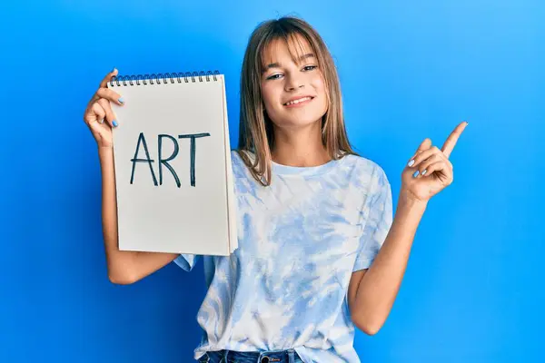 Adolescente Caucasiano Menina Segurando Arte Caderno Sorrindo Feliz Apontando Com — Fotografia de Stock