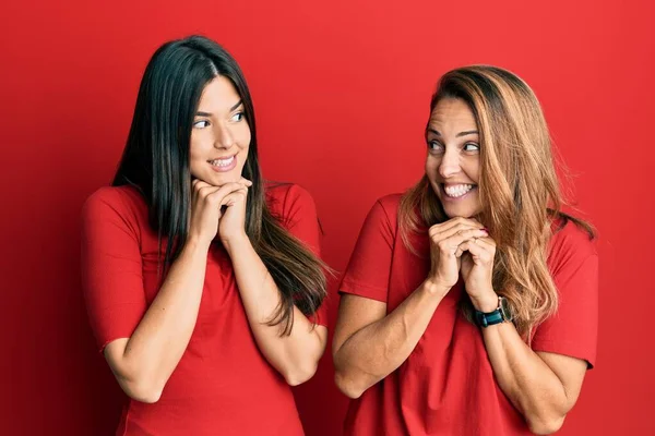 Família Hispânica Mãe Filha Vestindo Roupas Casuais Sobre Fundo Vermelho — Fotografia de Stock