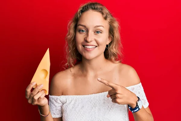 Hermosa Mujer Caucásica Sosteniendo Pedazo Queso Emmental Sonriendo Feliz Señalando — Foto de Stock