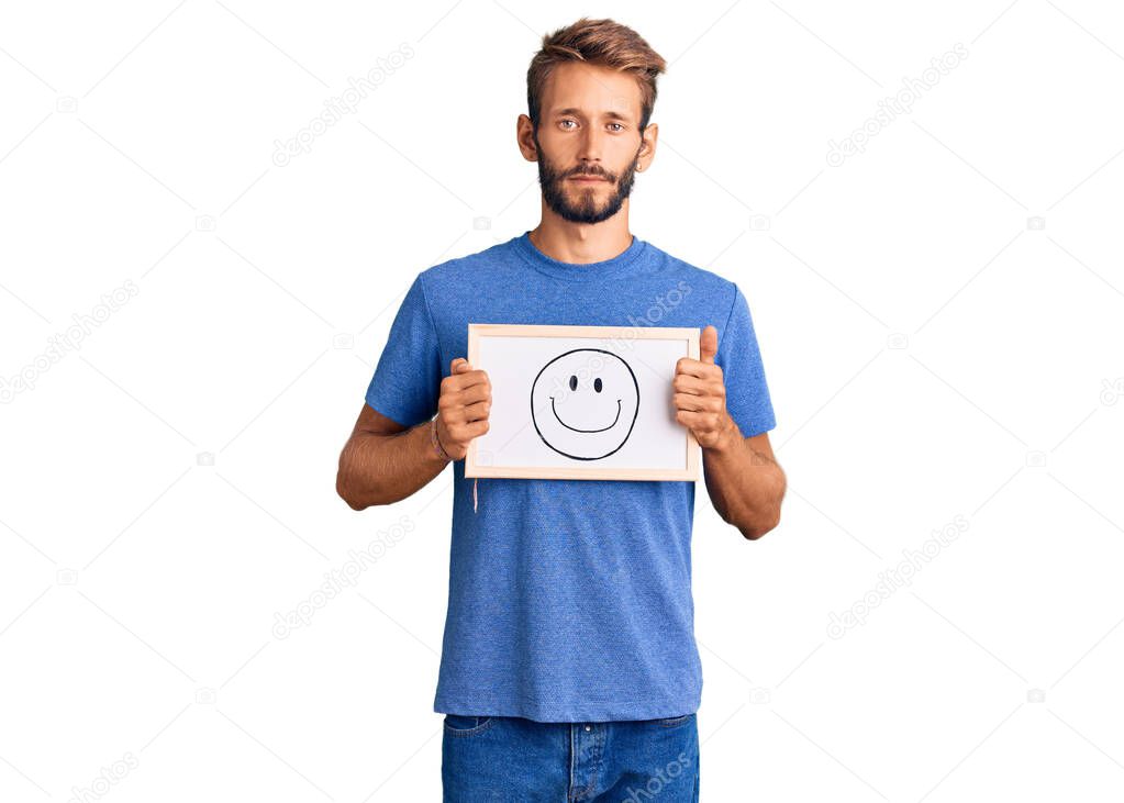 Handsome blond man with beard holding blackboard with happy face thinking attitude and sober expression looking self confident 
