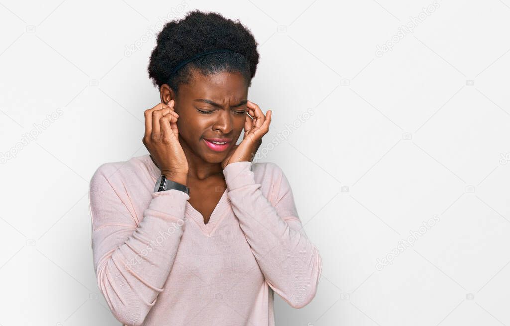 Young african american girl wearing casual clothes covering ears with fingers with annoyed expression for the noise of loud music. deaf concept. 