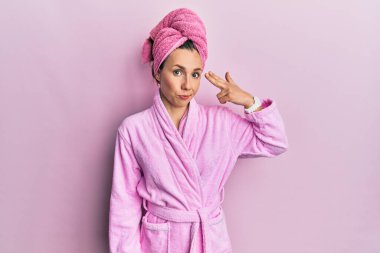 Duş başlığı ve bornoz takan genç sarışın kadın kendini vuruyor ve öldürüyor. Elini ve parmaklarını silah gibi kullanıyor. İntihar jesti.. 