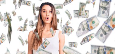 Kolsuz tişört giyen genç ve güzel bir kız. Şaşırmış ve korkmuş bir ifade, korku ve heyecanlı bir yüz ifadesi var..