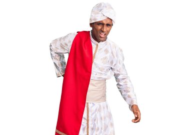 Geleneksel giyinmiş Afrikalı yakışıklı bir adam Sherwani sari giysileri giyer sırt ağrısı çeker, elleriyle dokunur, kas ağrısı çeker. 