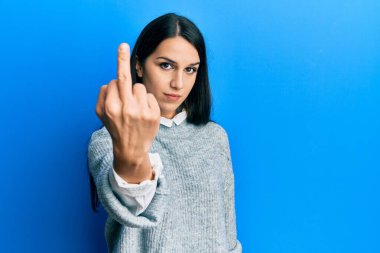 Young hispanic woman wearing casual clothes showing middle finger, impolite and rude fuck off expression 