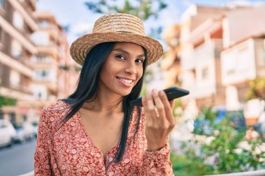 Genç Afro-Amerikan turist kadın tatilde. Şehirdeki akıllı telefondan sesli mesaj gönderiyor..