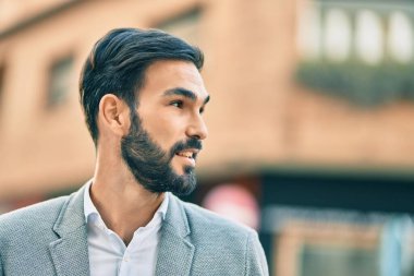 Genç İspanyol işadamı gülümseyerek şehirde mutlu mesut duruyor..