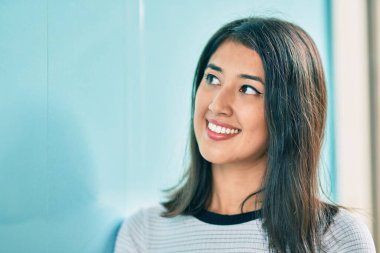 Genç İspanyol kadın gülümsüyor mutlu bir şekilde şehrin duvarına yaslanıyor..