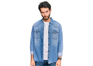 Gündelik kıyafetler giyen, kuşkucu ve gergin genç İspanyol bir adam sorun yüzünden surat asıyor. negatif kişi. 