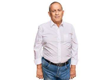 Zarif beyaz gömlek giyen yakışıklı bir adam. Yüzünde ciddi bir ifadeyle rahatlamış. Basit ve doğal bir şekilde kameraya bakıyorsun.. 