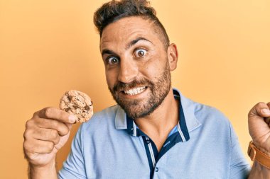 Sakallı yakışıklı adam gururla bağırıyor zaferi ve başarıyı kutluyor. 