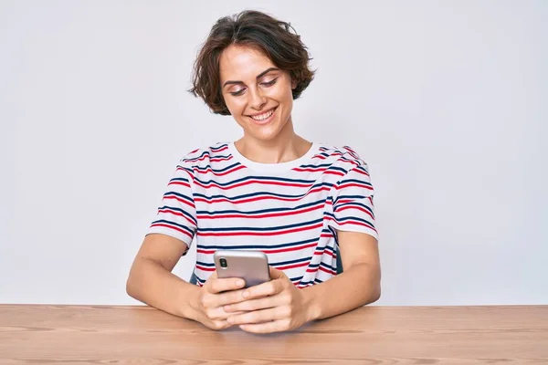 Ung Latinamerikansk Kvinna Med Smartphone Sitter Bordet Ser Positiv Och — Stockfoto