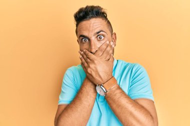 Sıradan kıyafetler giyen yakışıklı bir adam yanlışlıkla elleri ile ağzını kapatırken şok oldu. gizli kavram. 