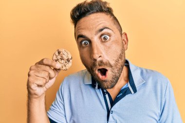 Sakallı, kurabiyeli yakışıklı adam korkmuş ve ağzı açık kalmış, şaşırmış ve şaşırmış. 