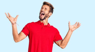 Sarışın, sakallı, sıradan kıyafetler giyen, deli gibi bağıran, sinirli ifadeli ve kollarını kaldırmış yakışıklı bir adam. hüsran kavramı. 