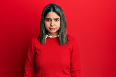 Gündelik giysiler giyen genç Latin kadın üzgün ve endişeli, kızgın ve korkmuş bir şekilde ağlıyor. hüzünlü ifade. 