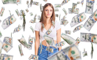 Gündelik beyaz tişört giyen genç, güzel sarışın kadın yüzünde ciddi bir ifadeyle rahatlamış. Basit ve doğal bir şekilde kameraya bakıyorsun..