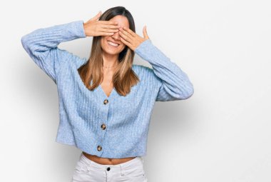 Günlük kıyafetler giyen genç bir kadın. Gözleri kapayan, neşeli ve komik gülümseyen bir kadın. kör kavram. 