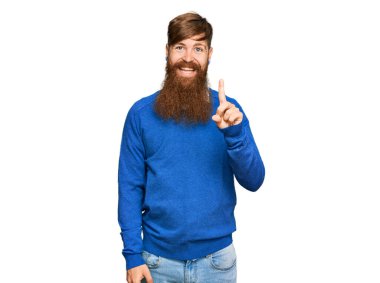 Genç İrlandalı kızıl elbiseli adam bir numarayı gösterip işaret ederken kendinden emin ve mutlu gülümsüyor.. 