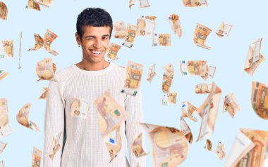 Genç Afrikalı Amerikalı sıradan kıyafetler giymiş, kameraya seksi bir ifadeyle bakıyor, neşeli ve mutlu bir yüzle..