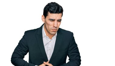 Hazımsızlık, acı verici bir hastalık ve midesi kötü hissettiği için iş kıyafetleri giyen yakışıklı bir İspanyol. Ağrı kavramı. 