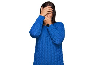 Gündelik kıyafetler giyen genç İspanyol kadın gözlerini ve ağzını elleriyle kapatıyor, şaşırmış ve şok olmuş. duygu gizleme 