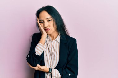 İş kıyafetleri giyen genç İspanyol kız kollarını kavuşturarak depresyondan sıkılmış ve yorgun görünüyor.. 