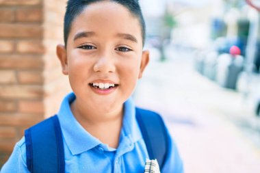 Sevimli öğrenci gülümsüyor. Şehrin caddesinde kitap tutarken mutlu..