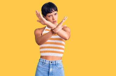 Kısa saçlı, esmer bir kadın. Günlük kıyafetler giyiyor. Reddedilmiş. 