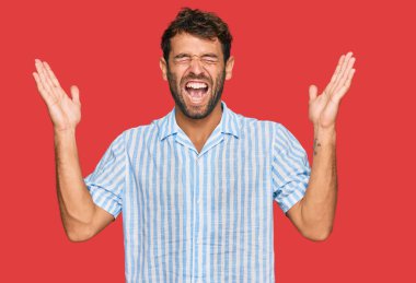 Yakışıklı, sakallı genç bir adam, gündelik gömleğini giymiş, çılgın ve başarıyı kolları havada ve gözleri kapalı heyecanla haykırarak kutluyor. Kazanan konsept 