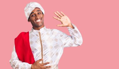 Gelenek giyinmiş Afrikalı yakışıklı bir adam Sherwani sari elbisesi giyiyor. Merhaba diyor, gülümsüyor ve gülümsüyor. 