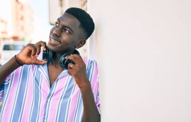 Şehrin caddesinde kulaklık kullanan Afrikalı genç bir Amerikalı..