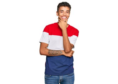 Genç, yakışıklı, Afro-Amerikan bir adam. Günlük kıyafetler giyip kameraya bakıyor. Kollarını kavuşturup, ellerini çenesine kaldırarak gülümsüyor. Olumlu düşünmek. 