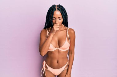 Bikini giyen güzel İspanyol kadın kendini kötü hissediyor ve soğuk algınlığı veya bronşitin belirtisi olarak öksürüyor. sağlık hizmeti kavramı. 
