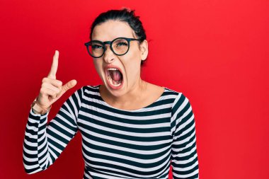 Gündelik kıyafetler giyen ve gözlüklü genç beyaz bir kadın başarılı bir fikri işaret ediyor. Heyecanlı ve mutlu. Bir numara.. 