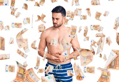 Mide üzerine mayo giyen genç yakışıklı bir adam. Çünkü hazımsızlık, acı verici bir hastalık ve kendini iyi hissetmiyor. Ağrı kavramı.