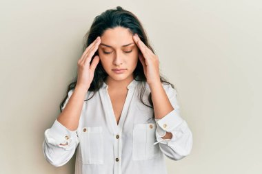 Güzel bir ortadoğulu kadın stres yüzünden elleri başının üstünde gündelik kıyafetler giyiyor. migren ağrısı. 