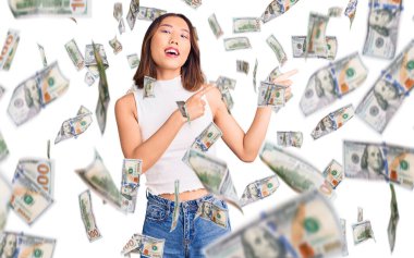 Genç, güzel Çinli bir kız. Günlük kıyafetler giymiş. Gülümsüyor ve kameraya bakıyor..