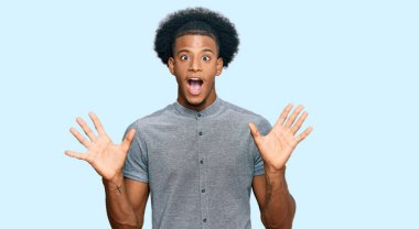 Afro saçlı Afrikalı bir adam çılgın kutlamalar yapıyor ve kolları açık, gözleri açık heyecanla haykırarak başarıyı kutluyor. Kazanan konsept 