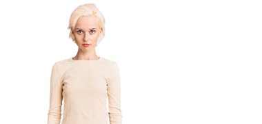 Sıradan kıyafetler giyen genç sarışın kadın yüzünde ciddi bir ifadeyle rahatlamış. Basit ve doğal bir şekilde kameraya bakıyorsun.. 