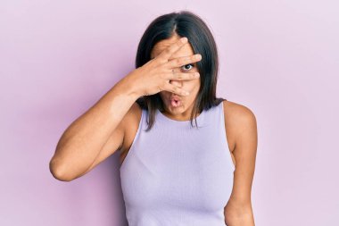 Genç esmer kadın gündelik giysiler giyiyor. Şoka girip yüzünü ve gözlerini eliyle kapatıyor. Korkuyla parmaklarından bakıyor. 
