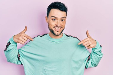 Günlük kıyafetler giyen, kendine güveni olan, kendini gururlu ve mutlu gösteren genç İspanyol bir adam.. 