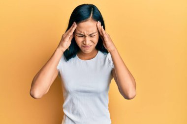 Güzel İspanyol kadın, stresten dolayı kafasında ağrı olsun diye günlük beyaz tişört giyiyor. migren ağrısı. 