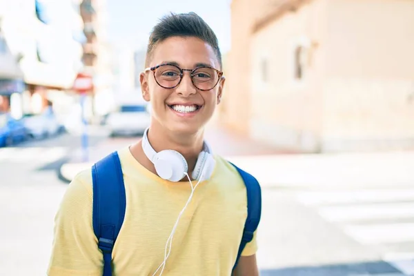 Νεαρός Ισπανός Φοιτητής Χαμογελώντας Χαρούμενος Χρησιμοποιώντας Ακουστικά Περπατώντας Στο Δρόμο — Φωτογραφία Αρχείου