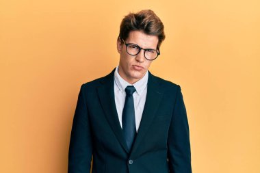 İş elbisesi giyen, kravat takan, kuşkucu ve gergin, sorun yüzünden kaşlarını çatan yakışıklı beyaz bir adam. negatif kişi. 