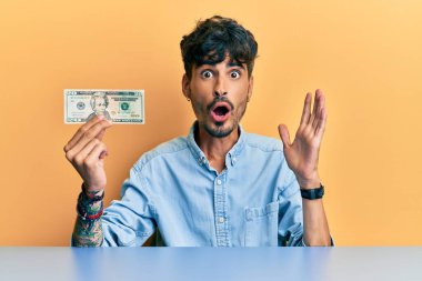 20 dolarlık banknot tutan İspanyol genç adam ağzı açık kalmış, korkmuş ve hayrete düşmüştü. 