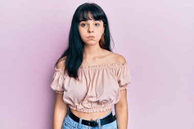 Günlük kıyafetler giyen genç İspanyol kız komik yüzlü yanakları şişiriyor. Havayla şişmiş ağız, çılgın bir ifade.. 